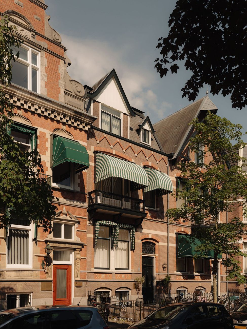 The front of the building on Maliestraat in Utrecht, with red brick, green striped awnings and a black front door